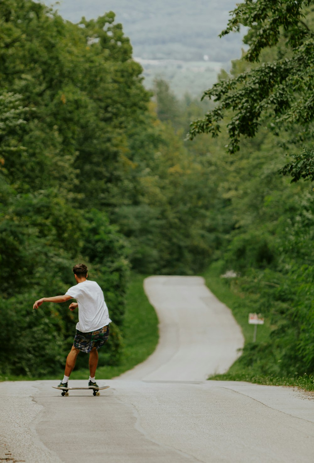 a man riding a skateboard down a curvy road