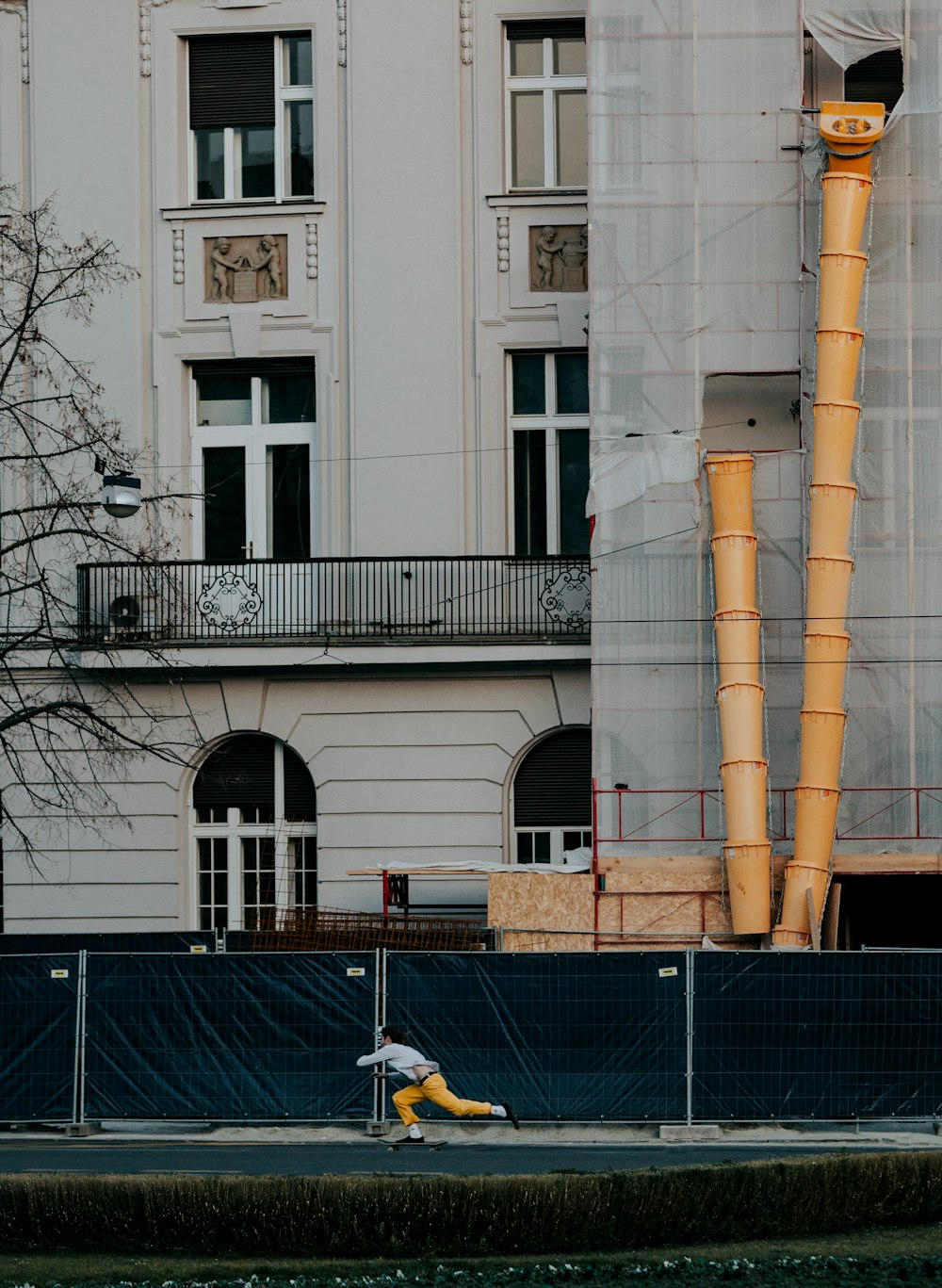 a man riding a skateboard down a street next to a tall building
