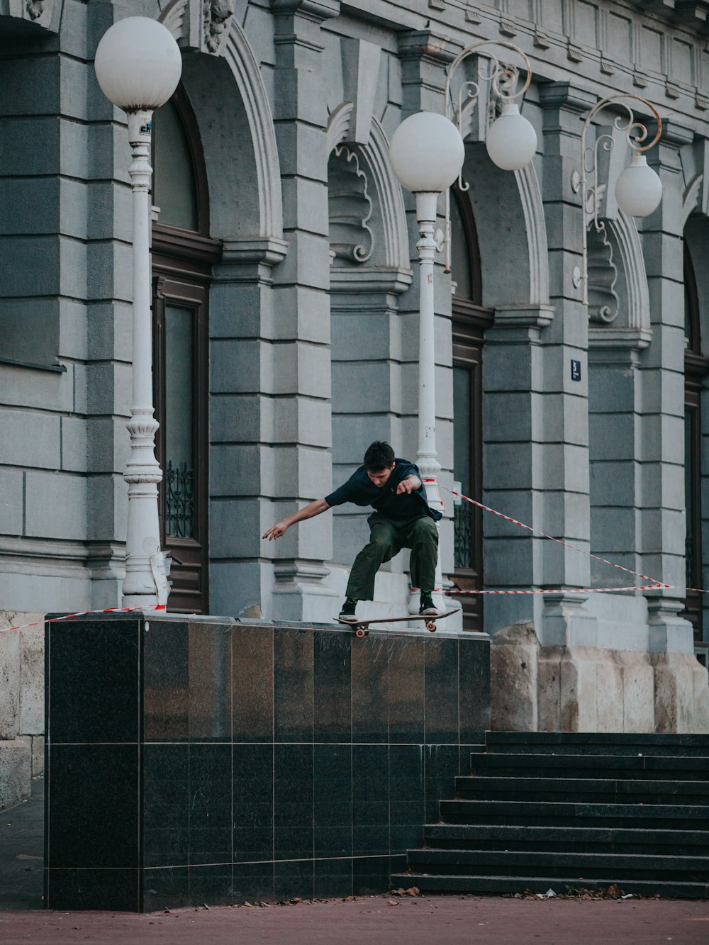 a man riding a skateboard down the side of a stone wall