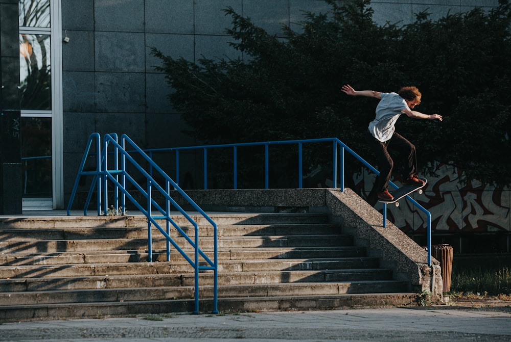 a man riding a skateboard down the side of a flight of stairs