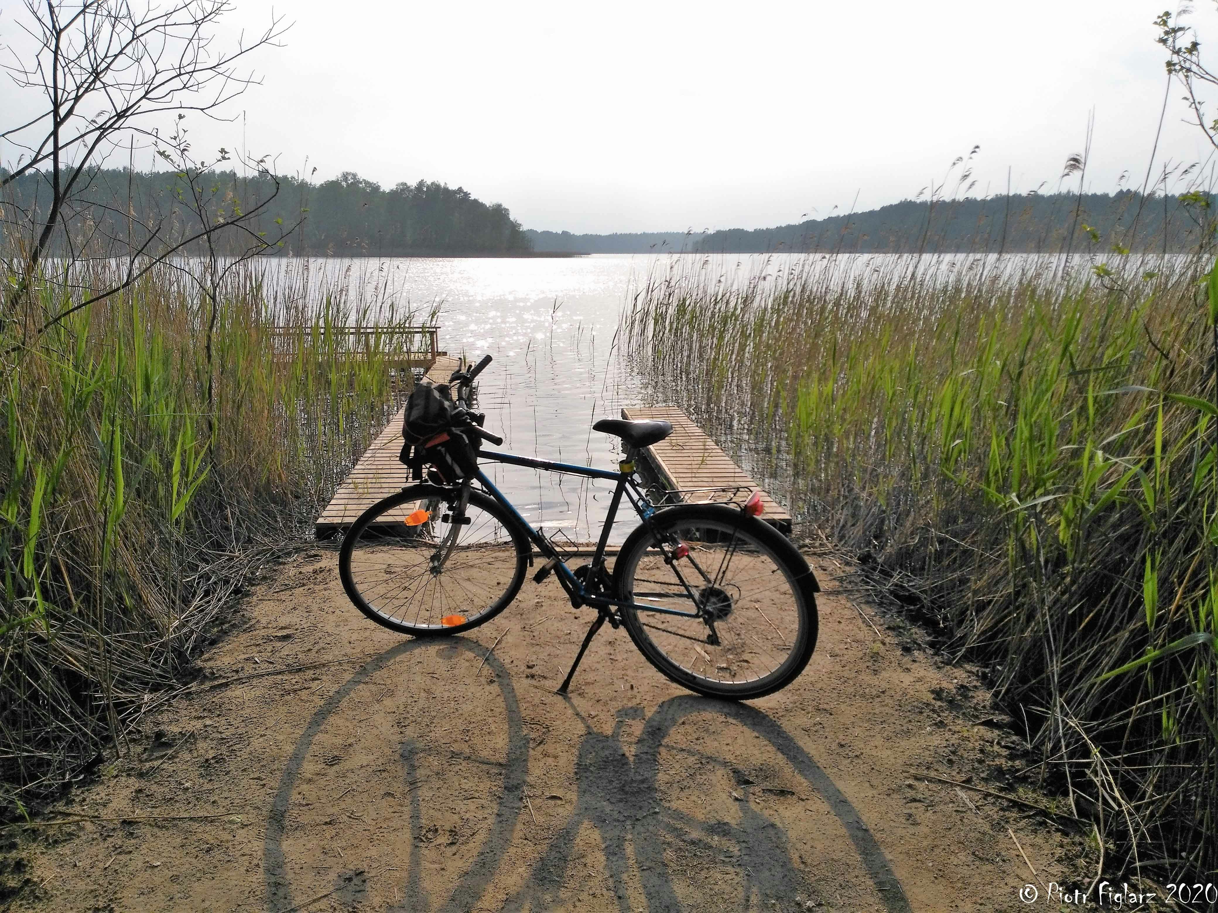 a bicycle parked on a wooden dock next to a body of water