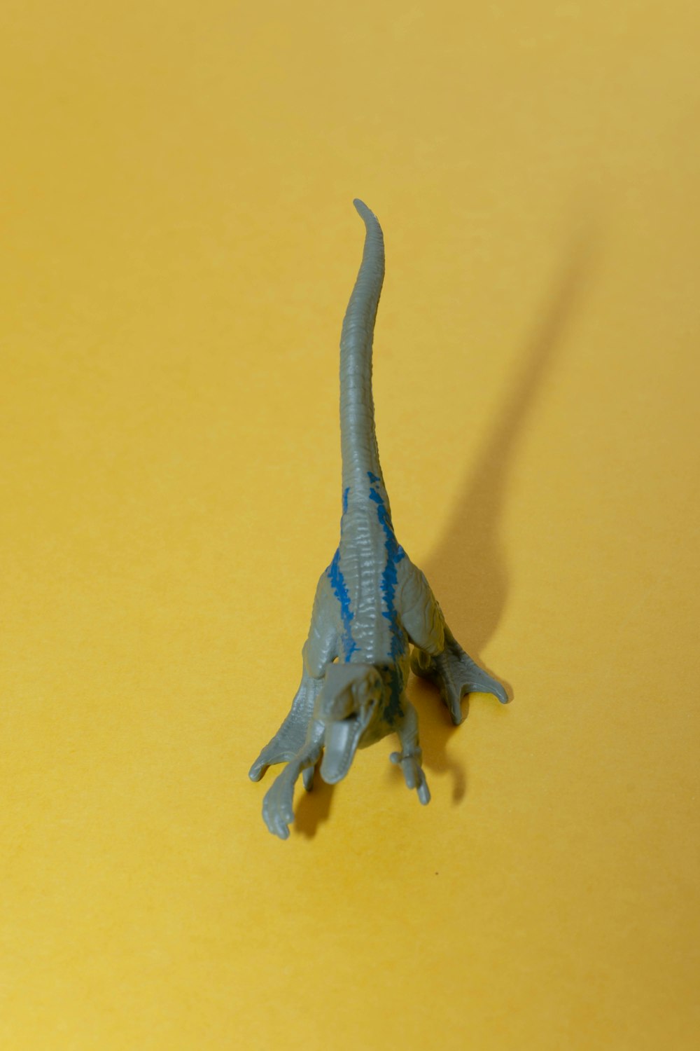 a toy dinosaur on a yellow surface