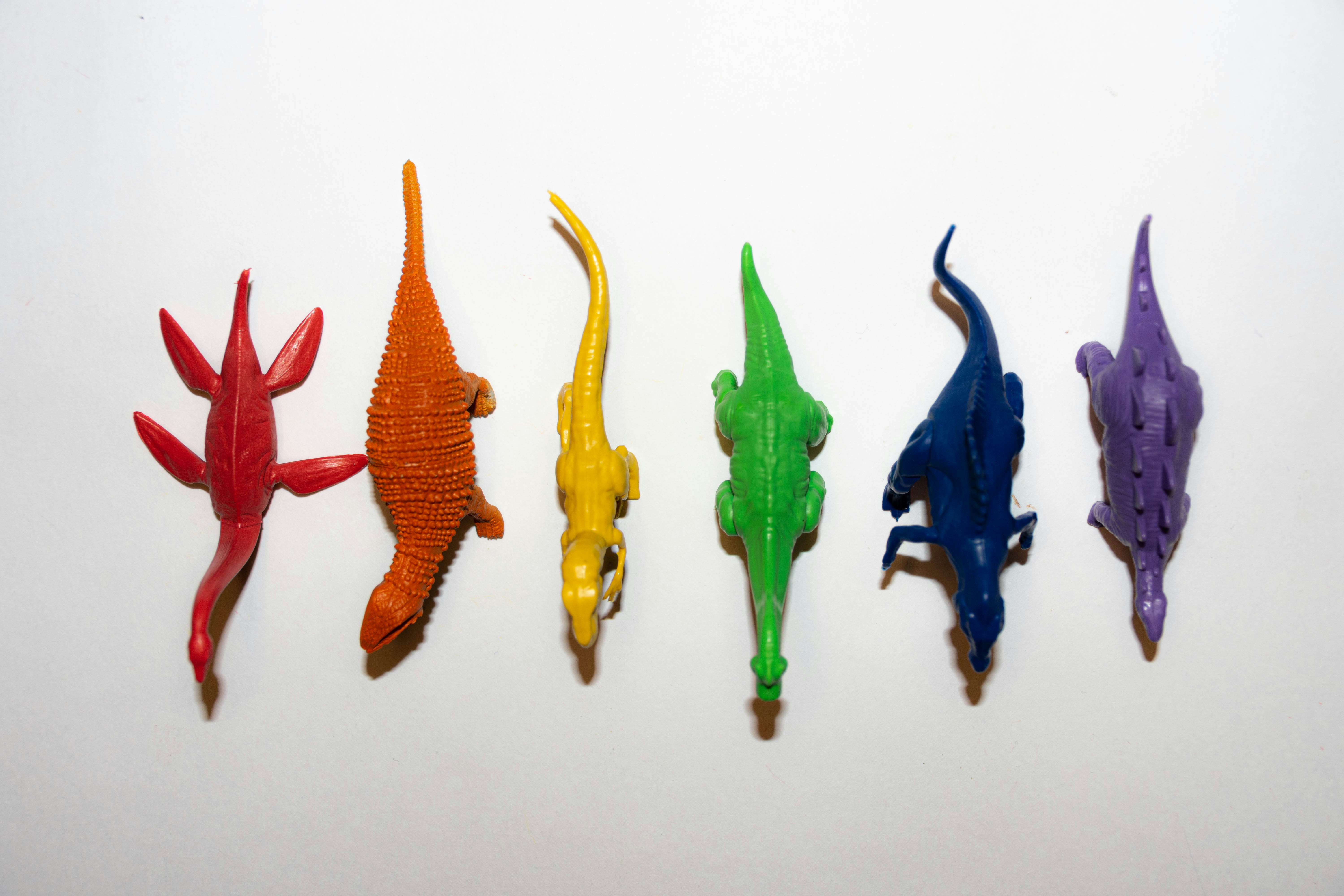 Colorful soft plush dinosaur toys set in various sizes on white background
