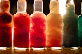 a row of bottles filled with different colored liquids