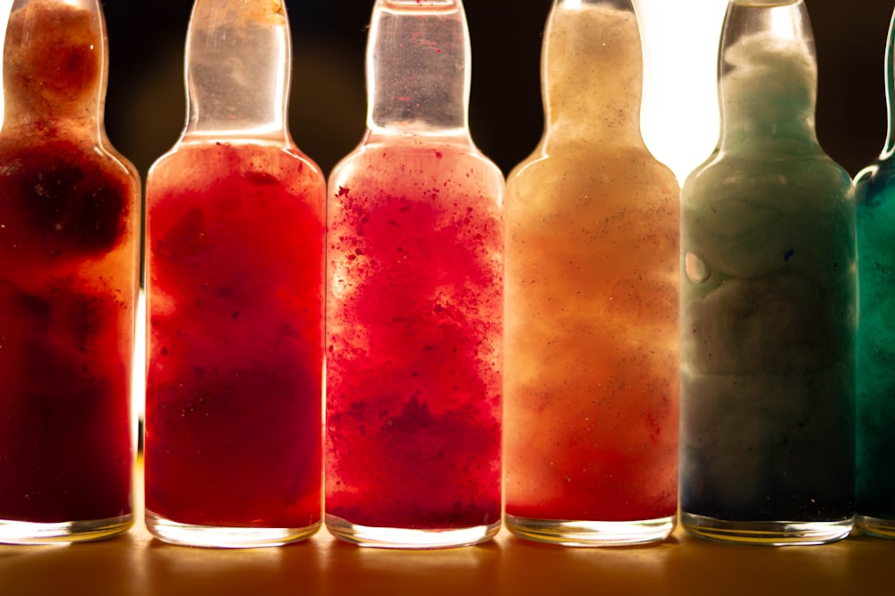 a row of bottles filled with different colored liquids