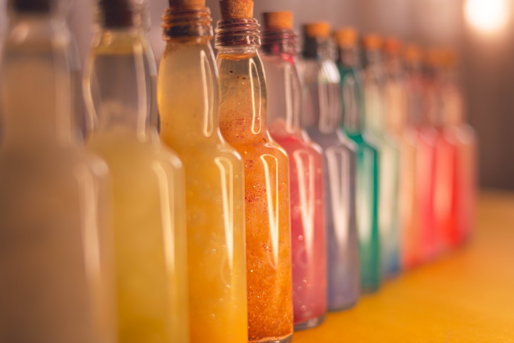 a row of bottles filled with different colored liquid
