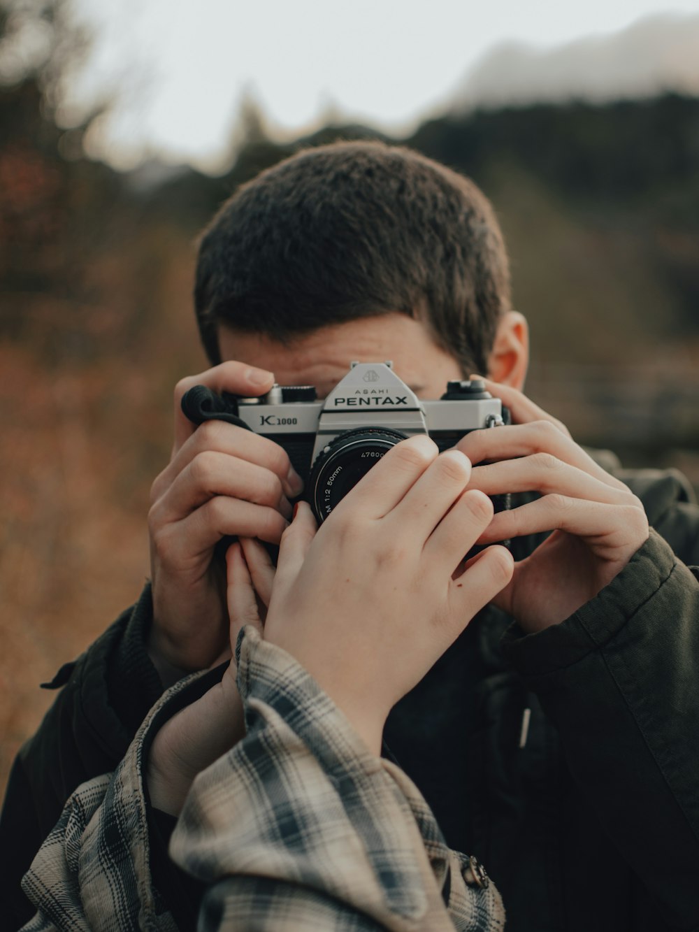 a boy holding a camera up to his face