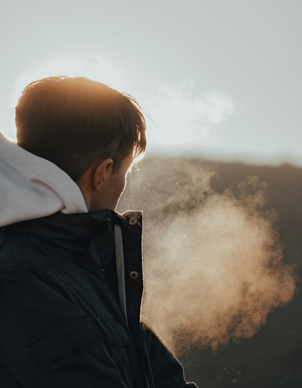 a man standing in front of a mountain covered in smoke