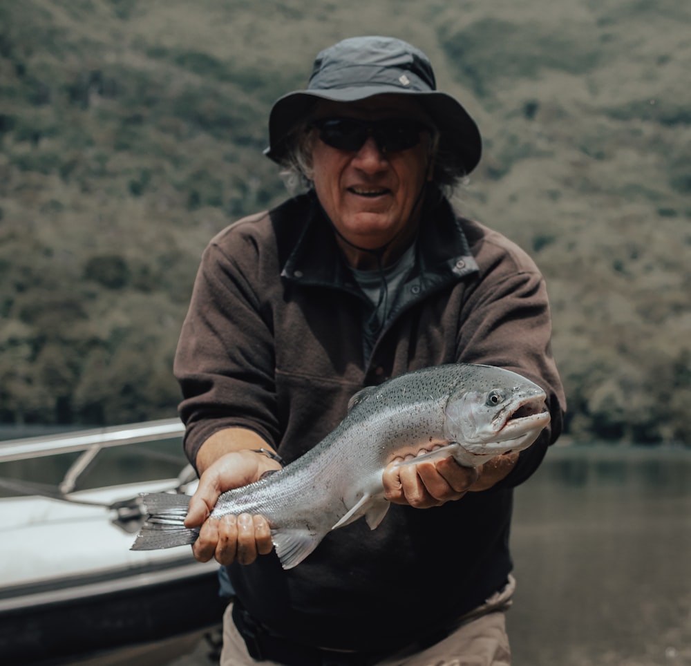 a man holding a fish on a boat