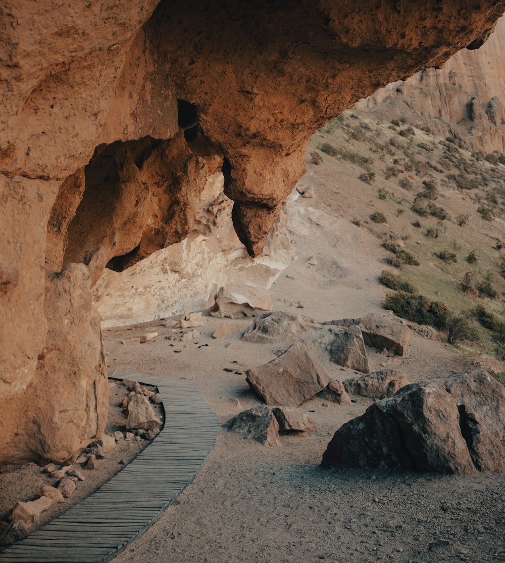 a wooden walkway leading to a cave in the desert