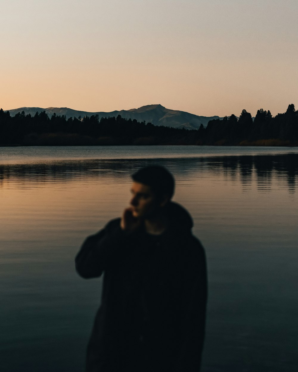 a man standing in front of a body of water