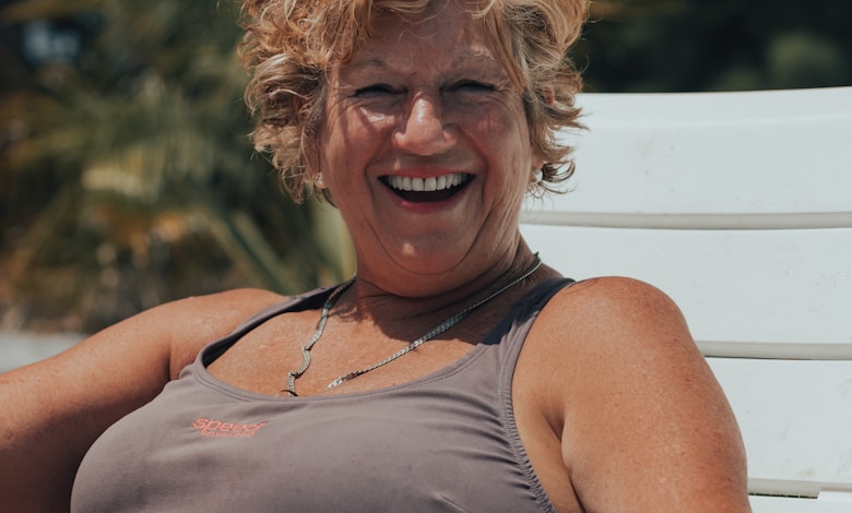 a woman sitting on a white bench smiling
