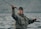 a woman holding a fishing rod while standing on a boat