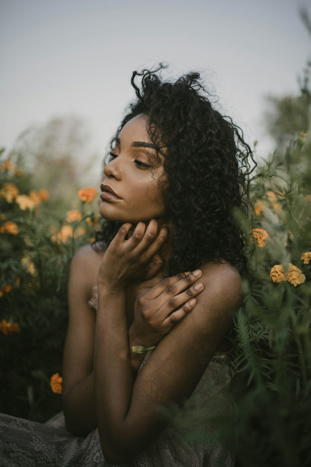 a woman sitting in a field of flowers