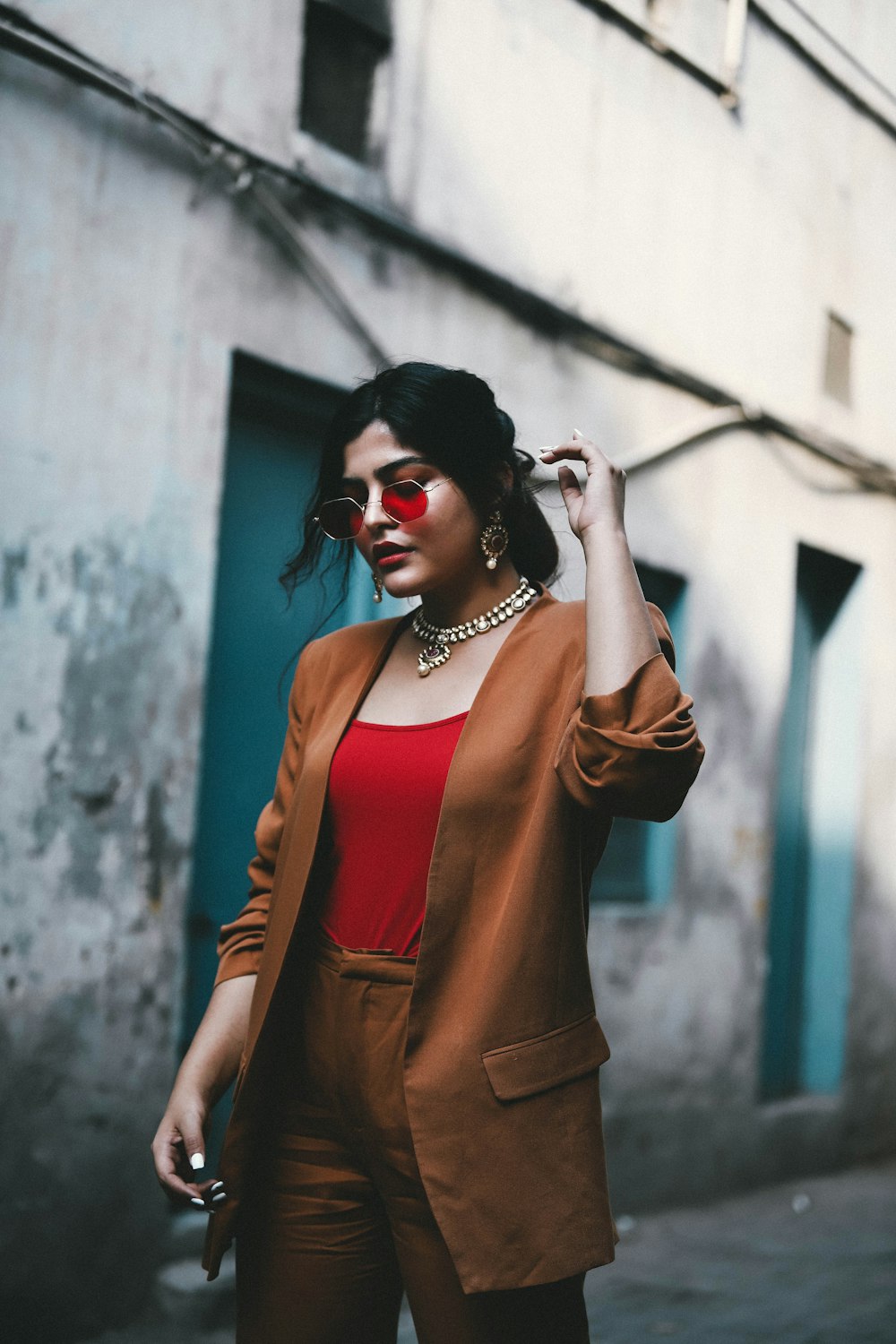 a woman in a red shirt and brown jacket