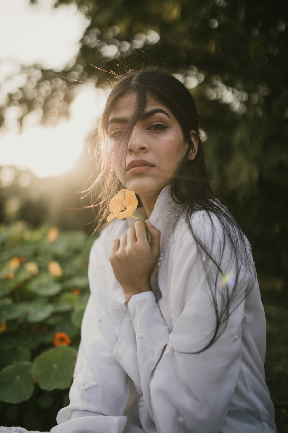 a woman sitting in a field of sunflowers