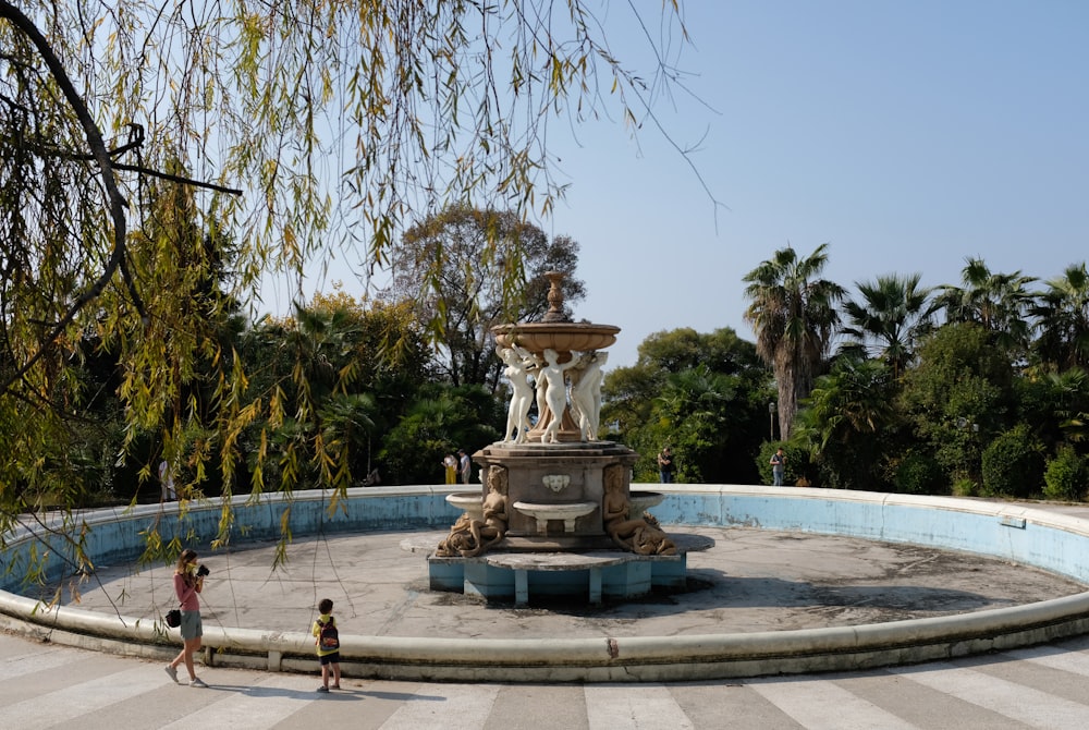 two children are standing in front of a fountain