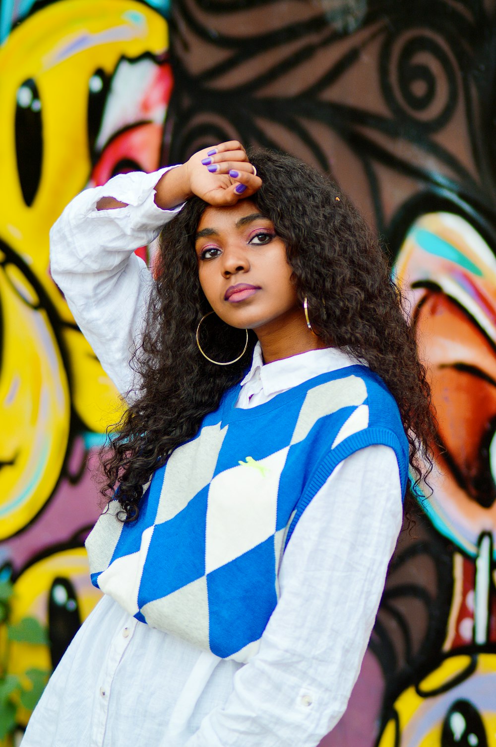 a woman standing in front of a colorful wall