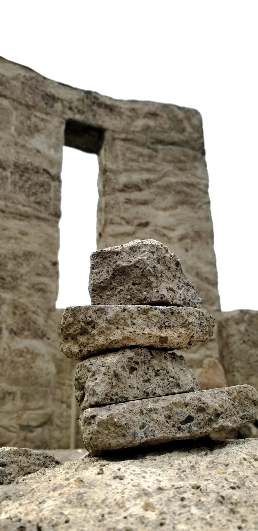 a stack of rocks sitting in front of a stone building