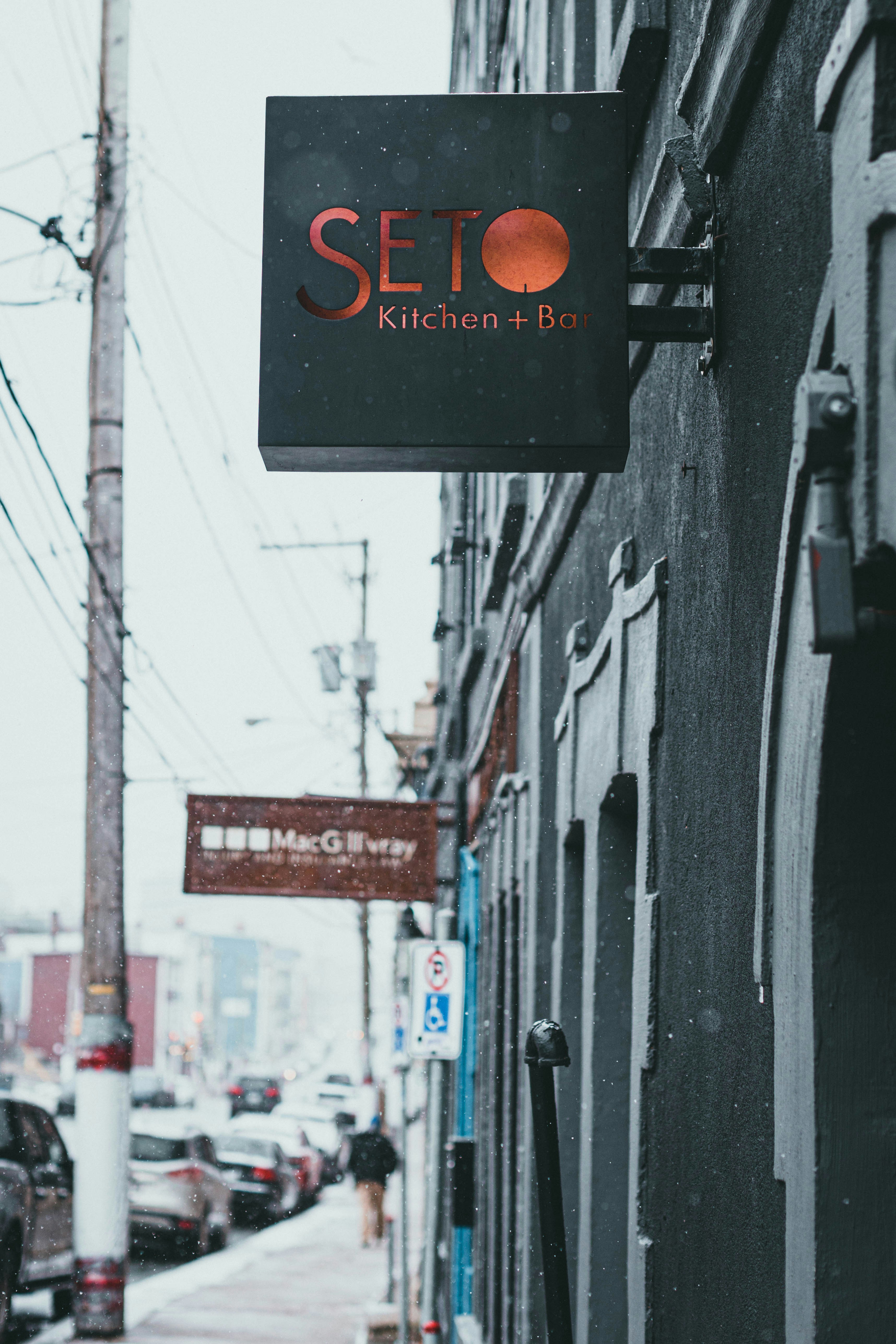 a restaurant sign hanging from the side of a building