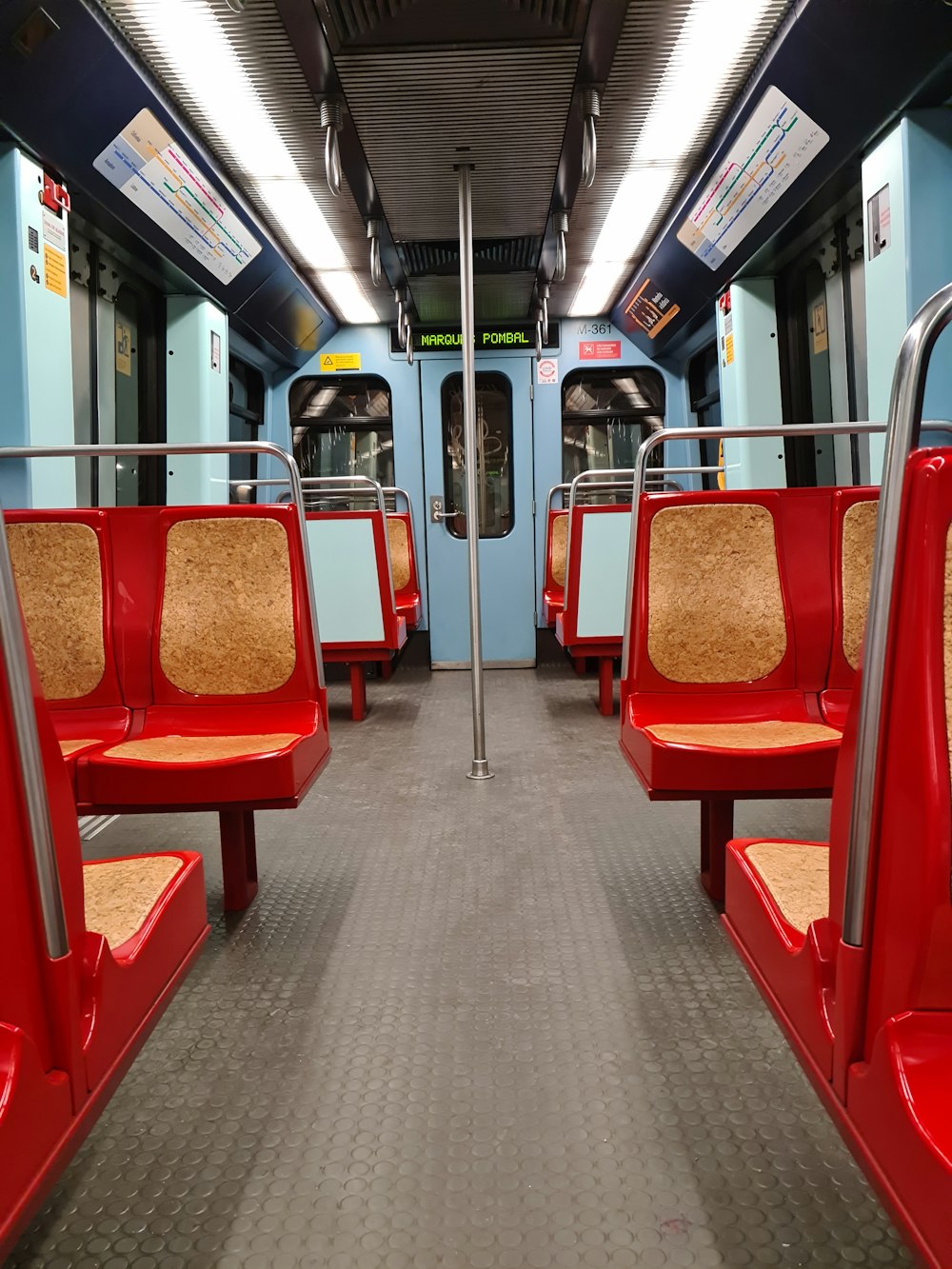 a subway car with red seats and metal railings