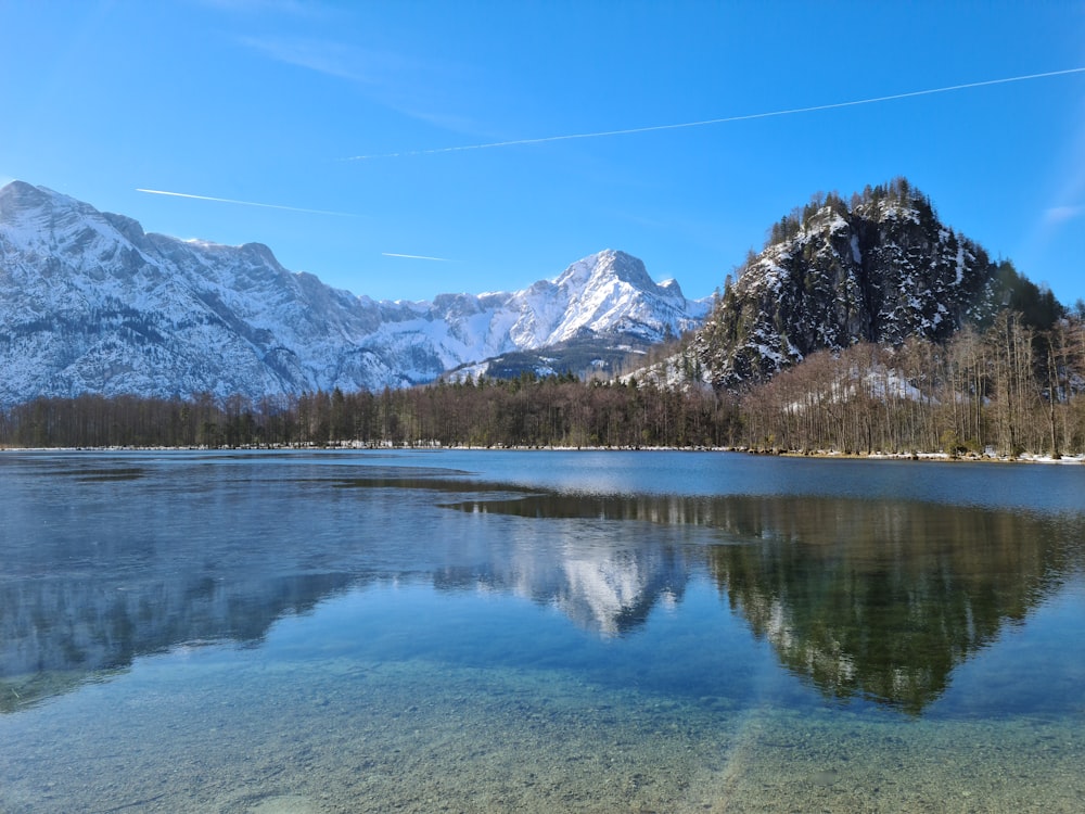 a mountain range is reflected in the still water of a lake