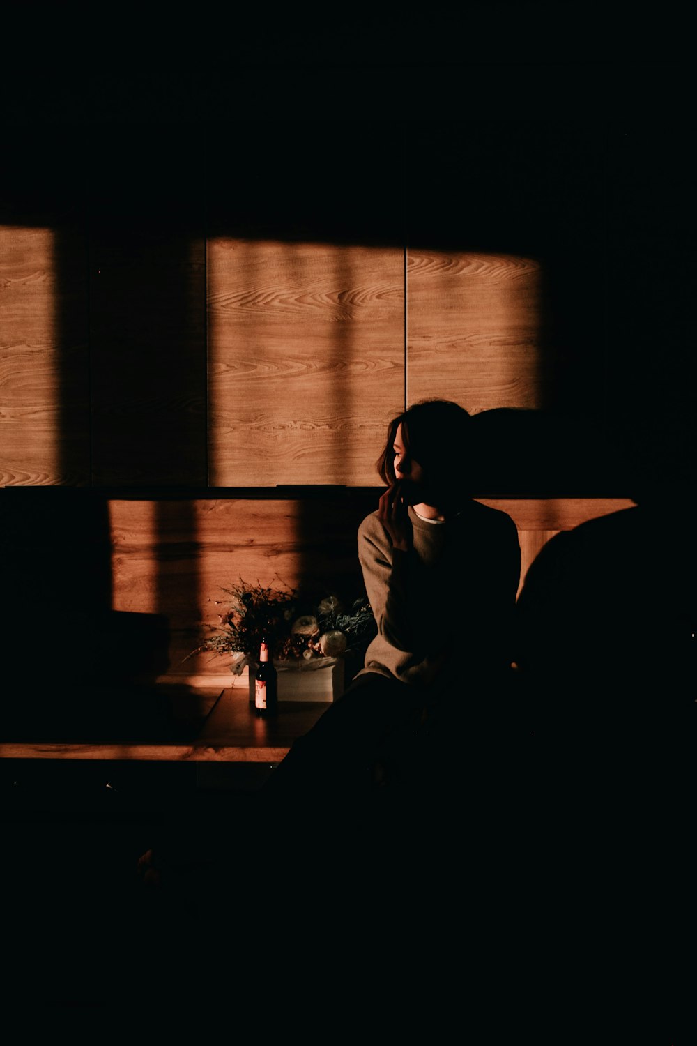 a woman sitting on a couch in a dark room