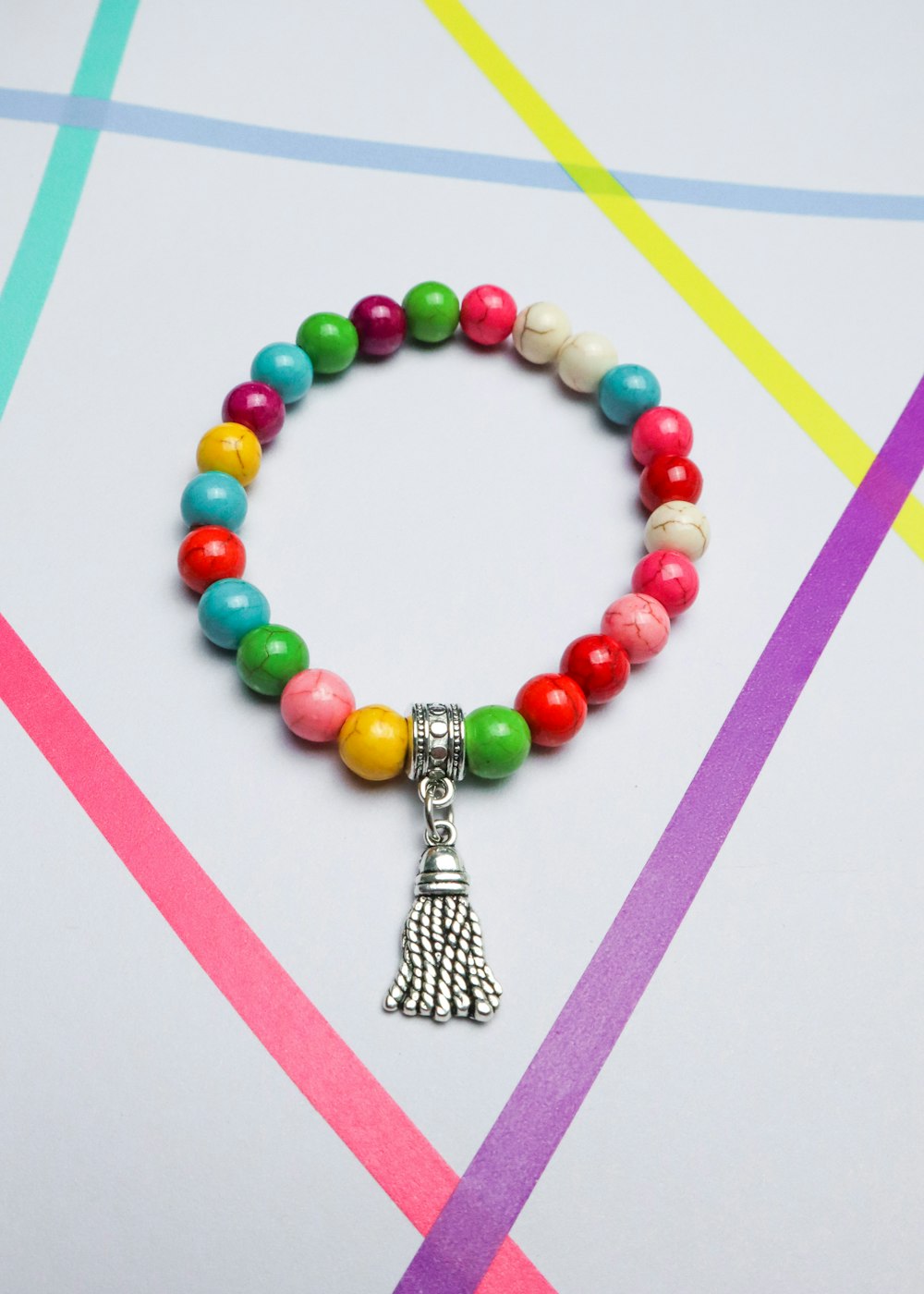 a colorful beaded bracelet with a hamsa hand charm