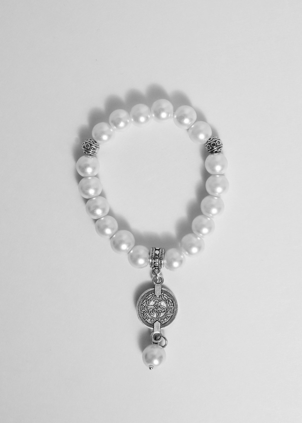 a white bracelet with a heart charm