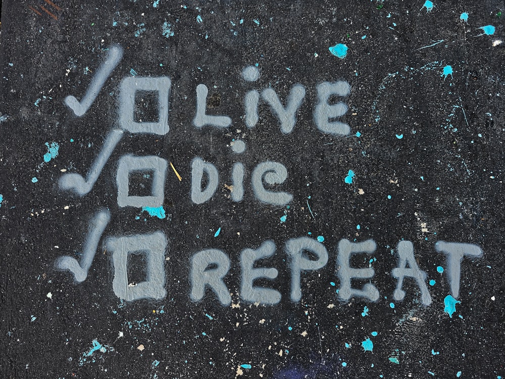graffiti written on the sidewalk saying live love repeat
