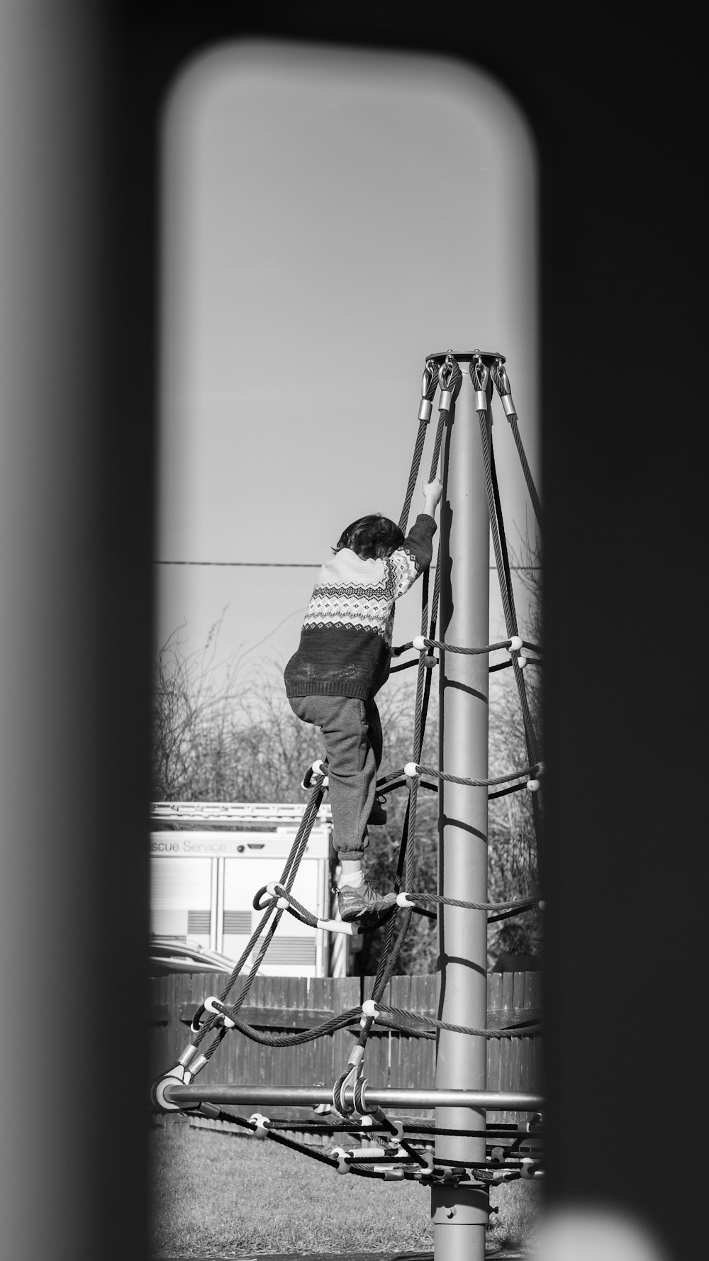 a person climbing up a metal pole