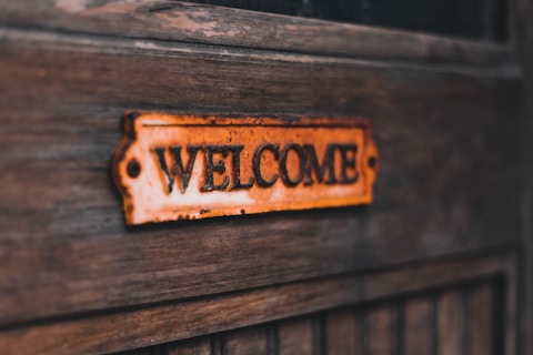 a close up of a welcome sign on a wooden door