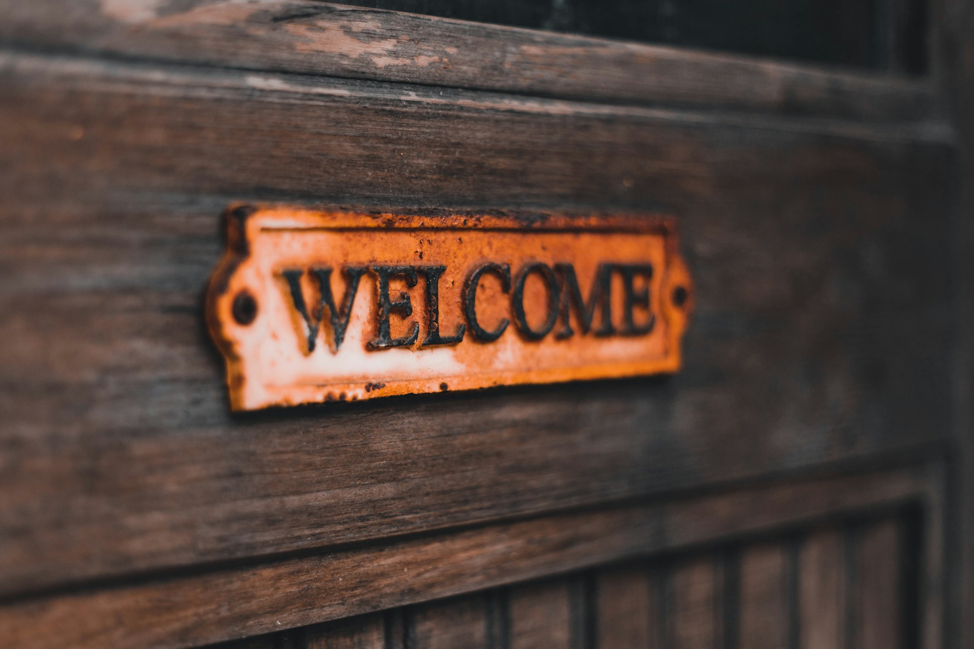 a close up of a welcome sign on a wooden door