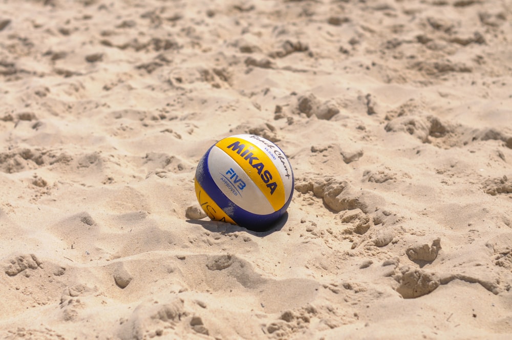 un ballon de volley couché dans le sable sur une plage