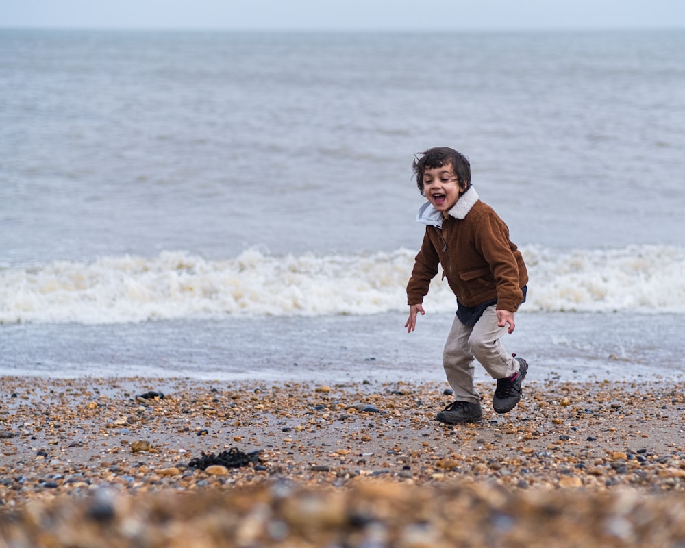 a young boy is playing on the beach