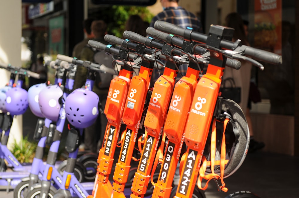 a row of orange scooters parked next to each other