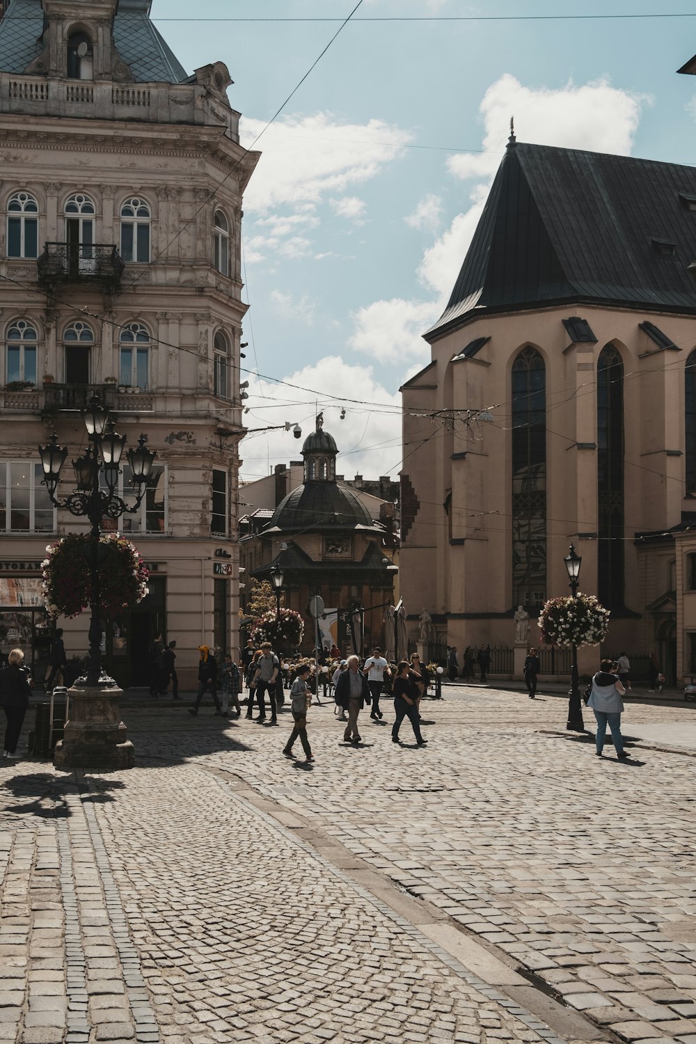 a group of people walking down a cobblestone street