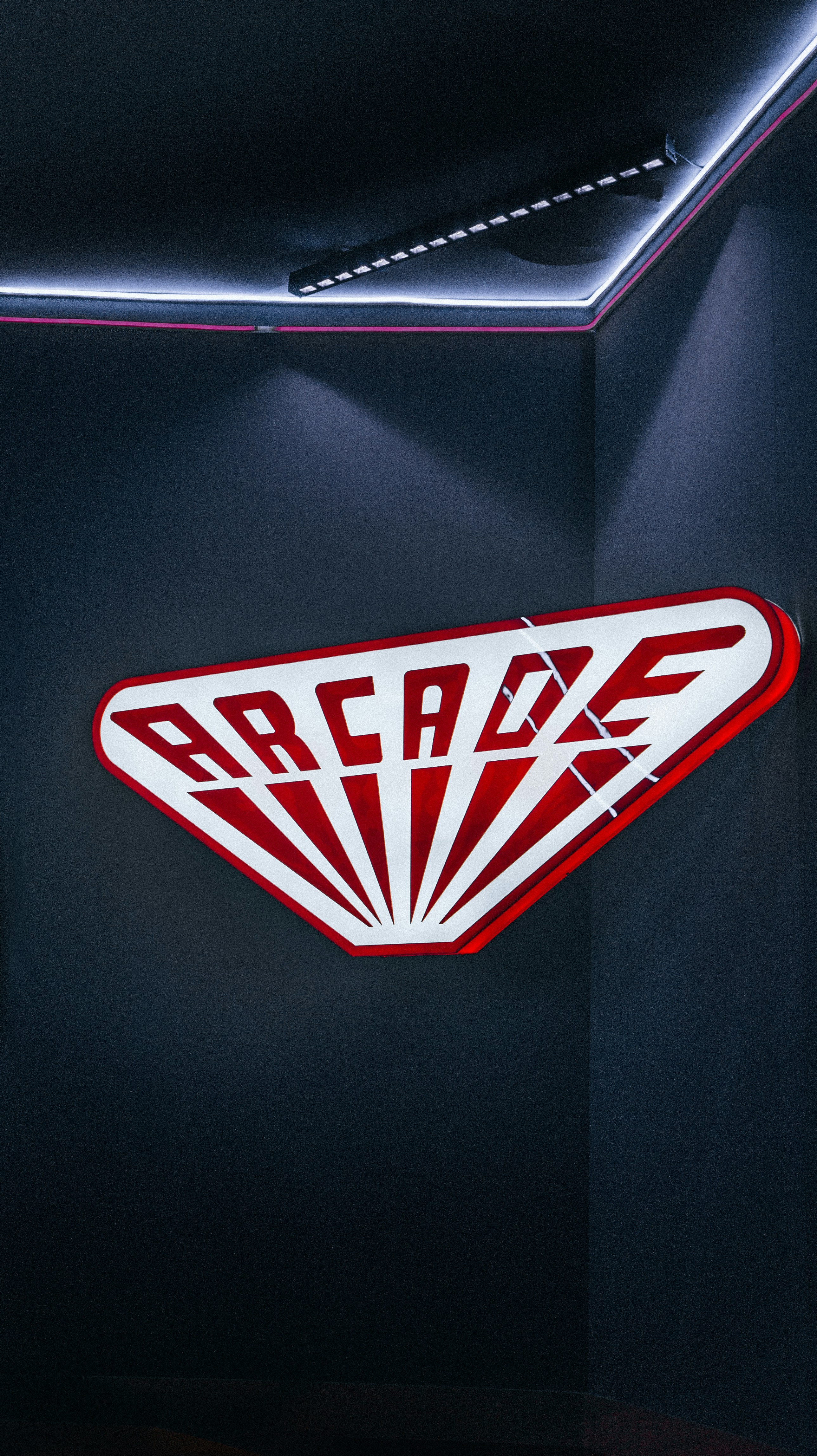 a red and white logo on a black wall