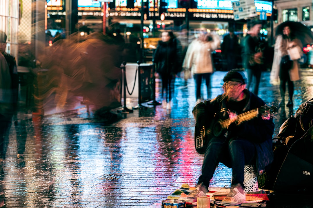 a man sitting on the ground playing a guitar,