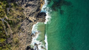 an aerial view of a body of water next to a cliff
