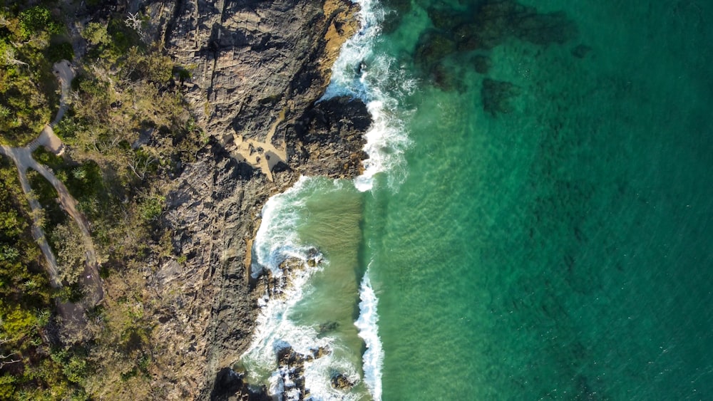 an aerial view of a body of water next to a cliff