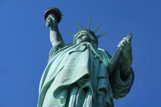 the statue of liberty is shown against a blue sky