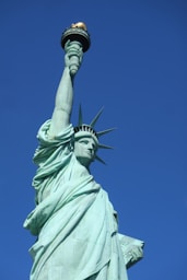 the statue of liberty is shown against a blue sky