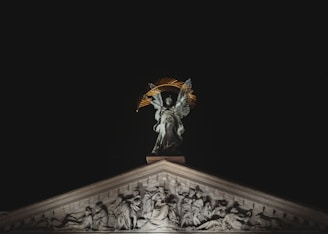 a statue on top of a building at night