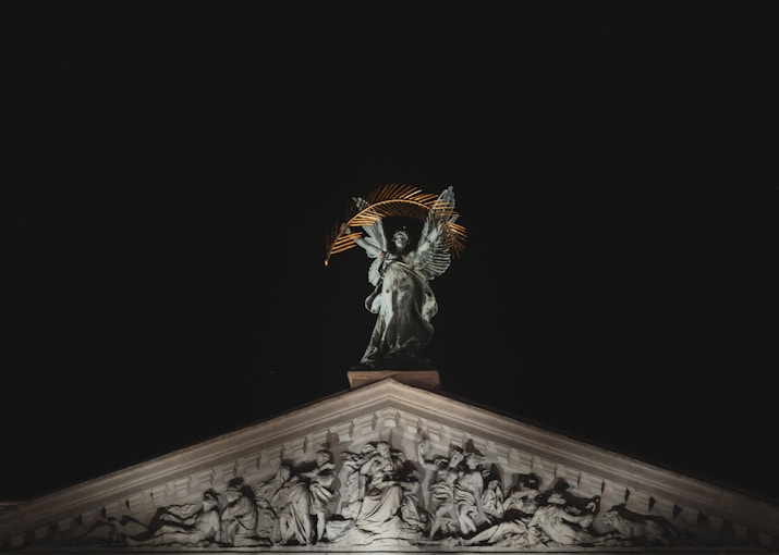 a statue on top of a building at night