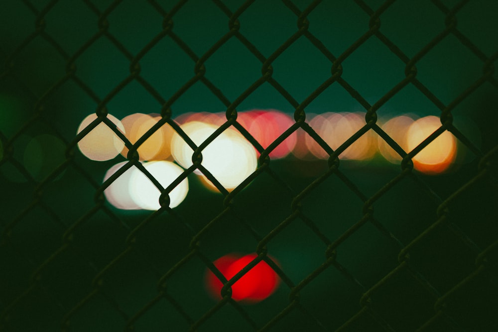 a blurry photo of a fence with lights behind it