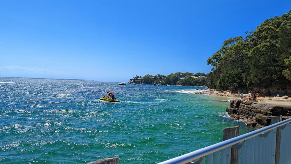 a person in a kayak on the water near a beach