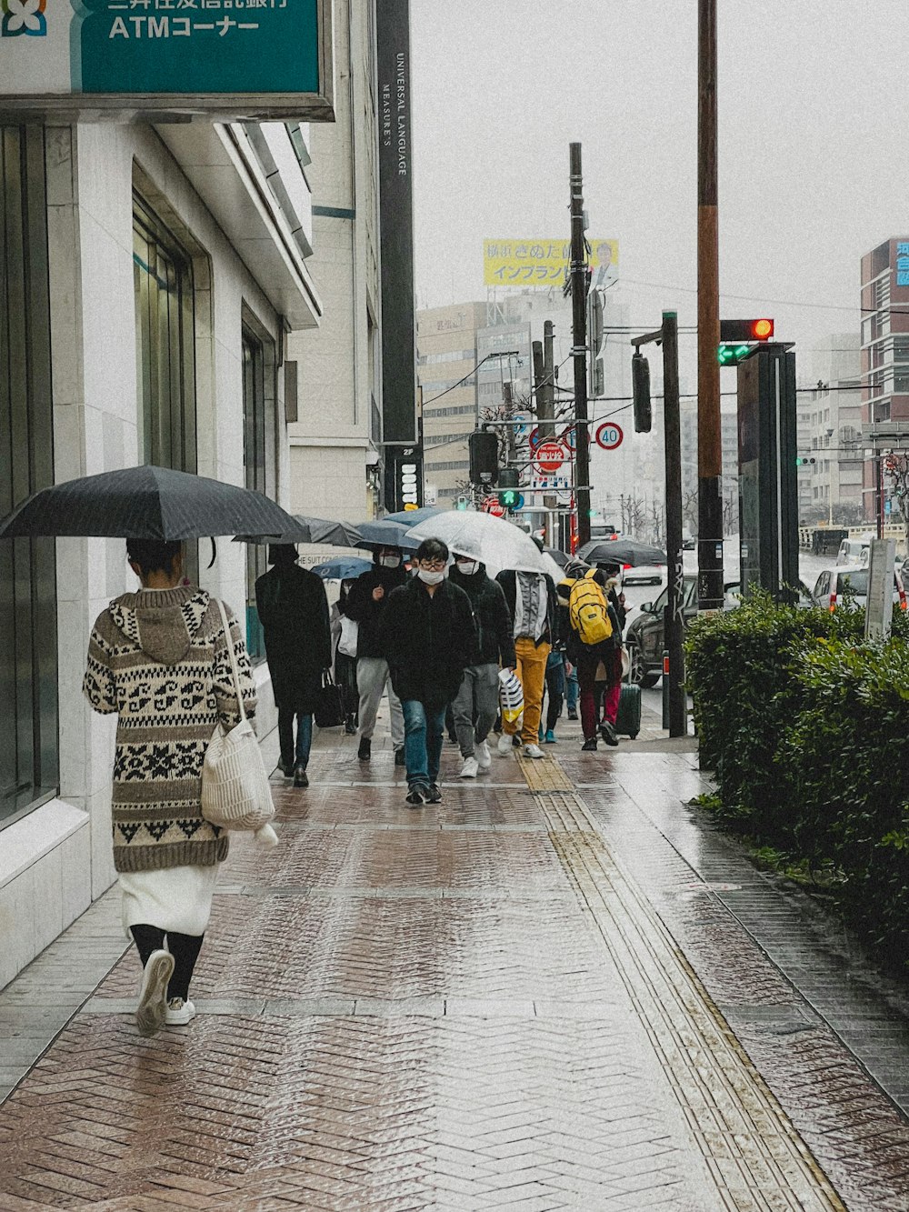 傘を持って通りを歩く人々のグループ