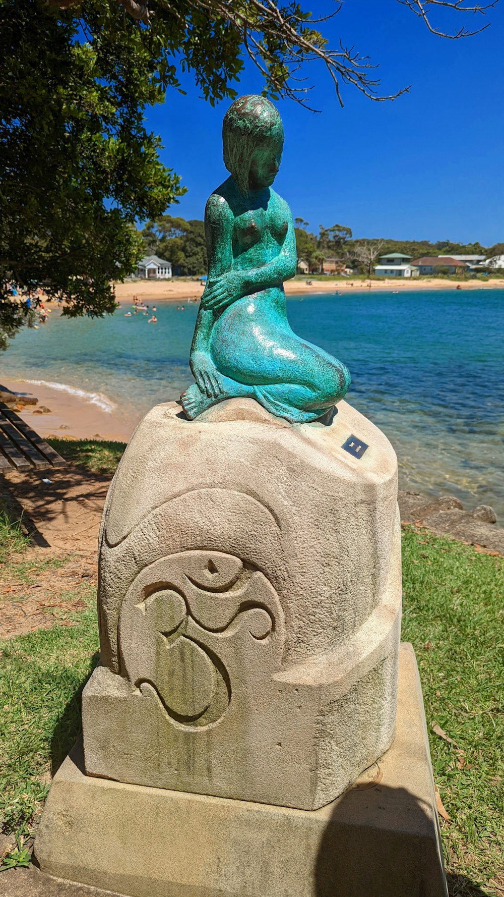 Eine Statue einer Meerjungfrau, die auf einem Felsen sitzt