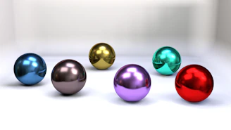 a group of shiny balls sitting on top of a white surface